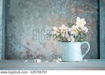 Spring Flowers In Jug On Old Wooden Painted Background