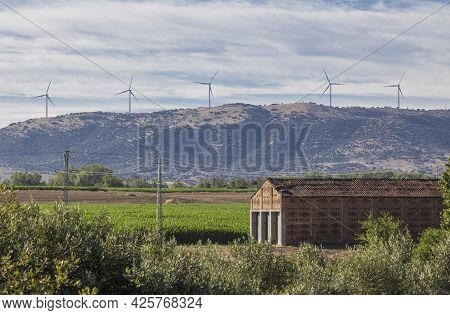 Tobacco Drying House With Electric Wind Turbines At Bottom. Carcaboso Countryside. Caceres, Extremad