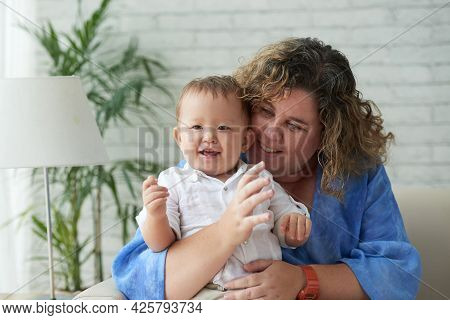 Portrait Of Happy Loving Plus Sive Woman Hugging Her Adorable Mixed-race Baby Boy