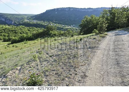Road Through The Karalez Valley With A View Of The Village Of Zalesnoye, Crimea, Russia. Summer Moun