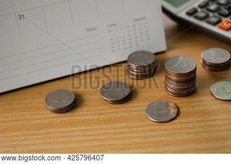 Stack Thai Coin With Calculator And Calendar On Wood Background. Planing Earn Investment And Saving 