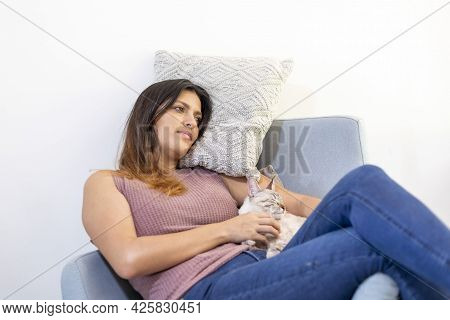 Young Latina Woman Resting A Chair With Her Cat.