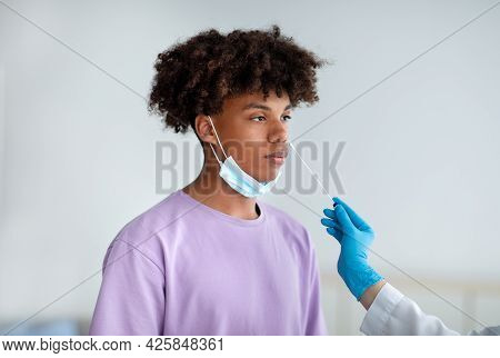 Covid Diagnostic And Testing. Doctor Making Nasal Coronavirus Pcr Test For Black Teenager, Using Swa