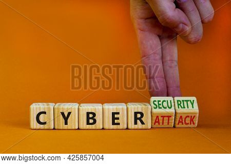 Cyber-security Vs Cyber-attack Symbol. Businessman Turns Wooden Cubes, Changes Words Cyber-attack To