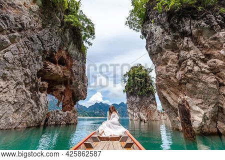 Young Female Tourist In Dress And Hat At Longtail Boat Near Famous Three Rocks With Limestone Cliffs
