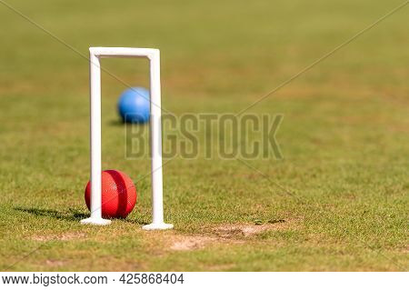 Reda Nad Blue Croquet Balls And Wicket On The Green Lawn On A Sunny Day