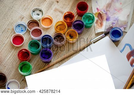Artists Desk: Brushes, Paints, Pencils, Crayons, Paper. Painting Tools And Drawing.