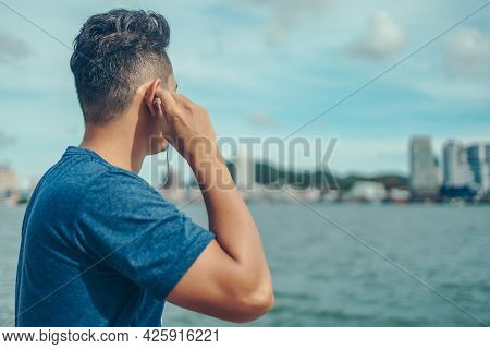 The Young Athlete Was Listening To Music And Looked At The City During His Break After Exercise. Mus