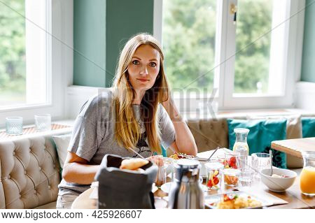 Young Confident Beautiful Woman Drinking Coffee And Having Breakfast. Happy Alone Woman In Indoor Ca