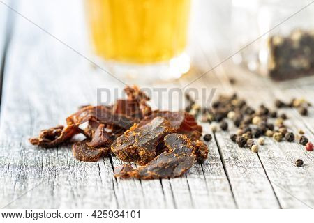 Sliced beef jerky. Dried beef meat on wooden table.