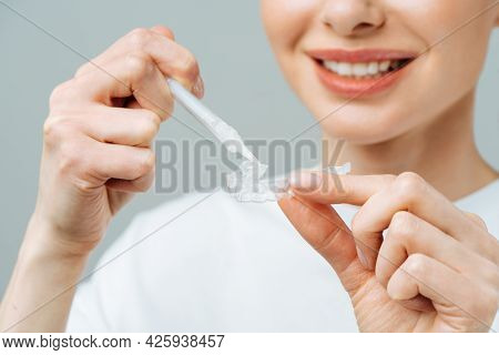 A Young Woman Does A Home Teeth Whitening Procedure. Whitening Tray With Gel