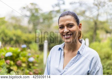 Portrait Of A Latina Woman In Outdoors, Smiling And Looking At Camera