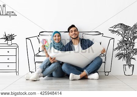Dreamy Arab Husband And Wife In Hijab Planning House Interior