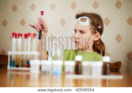 Ragazza in t-shirt verde Guarda ansiosamente provetta con esemplare nella sua mano