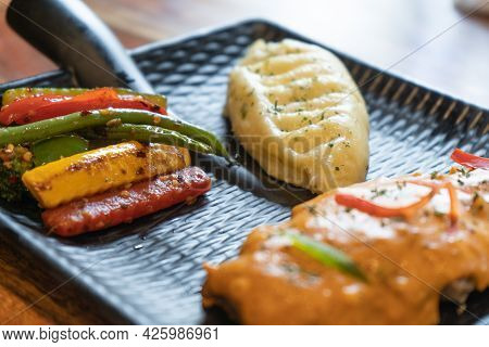 Three Quaters Shot Of Asthetic Modern Plate In Black Covered With Snack Of Mashed Potatoes Chili Sal