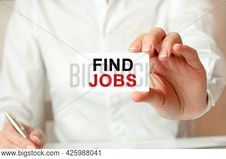 A Woman In A White Shirt Holds A Piece Of Paper With The Text: Find Jobs, Business Concept