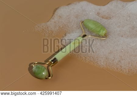 Green Jade Face Roller Lies In The Foam. Skin Care Tools. Beauty Roller For Better Blood Circulation