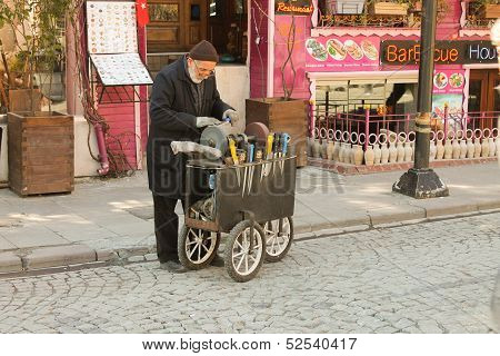 Man sharpens knives on the street in Istanbul.