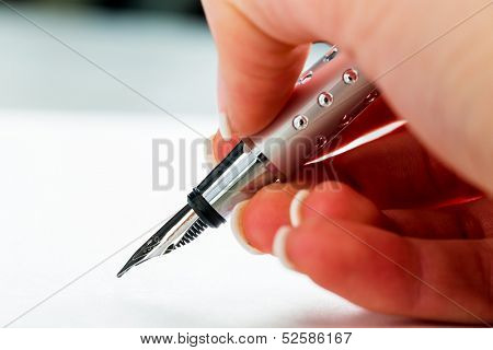 a hand with a fountain pen in the untrerschrift under a contract or testament.