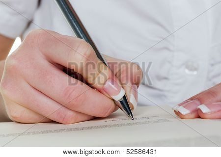 a woman signs a contract or a will with a fountain pen.