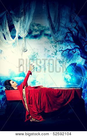 Bloodthirsty vampire woman lies in a coffin in the night cemetery.