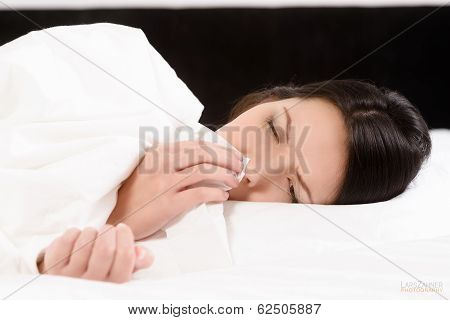 Sick Young Woman Blowing Her Nose On A Tissue