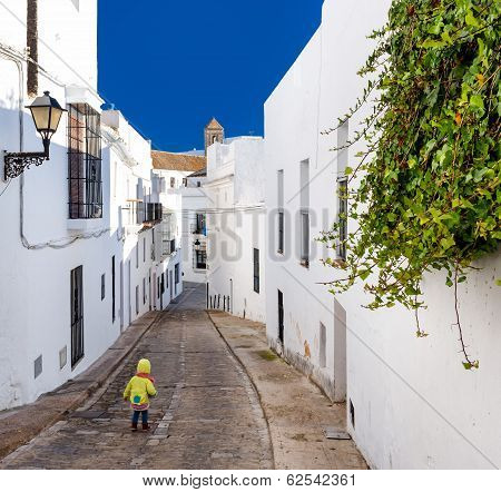 Baby Walking On Narrow Street Of Vejer De La Frontera. Costa De La Luz, Spain