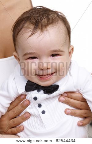 Closeup portrait of elegant smiling baby boy in shirt and bow tie.