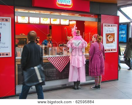 Girls In Carnival Costumes Near The Cafe Fast Food In Town Of Heusden