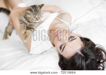 woman and her cat are sleeping on the bed