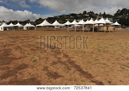 White Tents In A Dry Field Outdoors