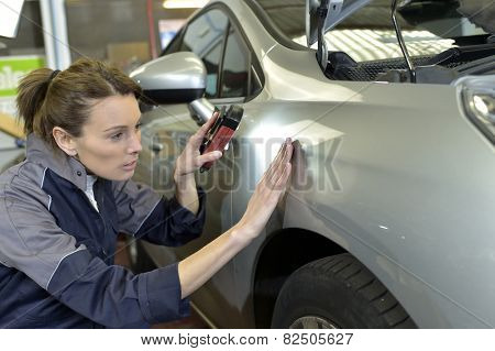 Woman technician working in auto bodywork shop