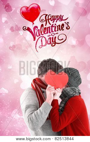 Couple holding a red heart against valentines heart design