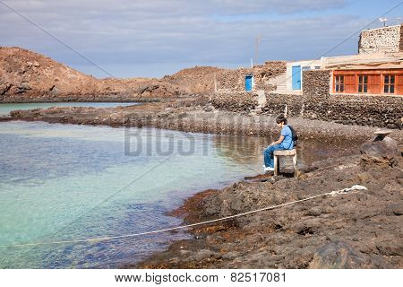 Two Brothers Sitting In The Small Port Of Isla De Lobos,  Canary Islands
