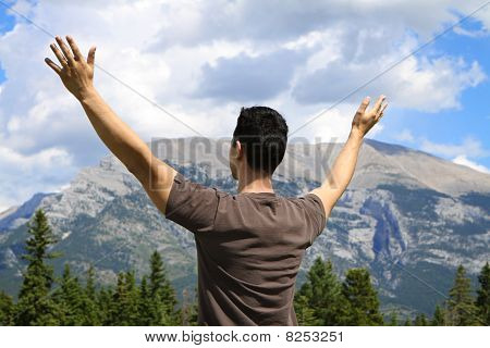 Homem permanente na natureza com braços levantado