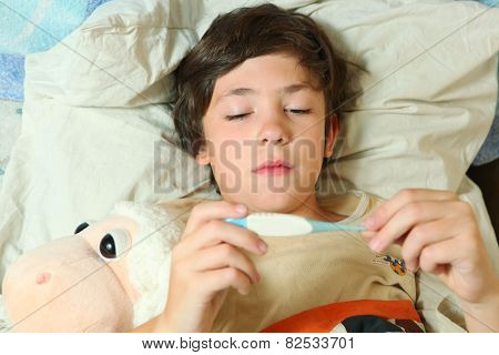 Sick Preteen Boy In Bed With Termometer Show High Temperature