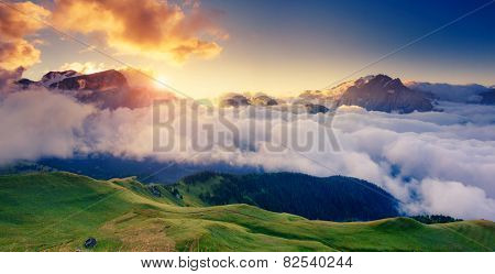 Great view of the foggy Val di Fassa valley with pass Sella. National Park. Dolomites (Dolomiti), South Tyrol. Location Canazei, Campitello, Mazzin. Italy, Europe. Dramatic scene. Beauty world.