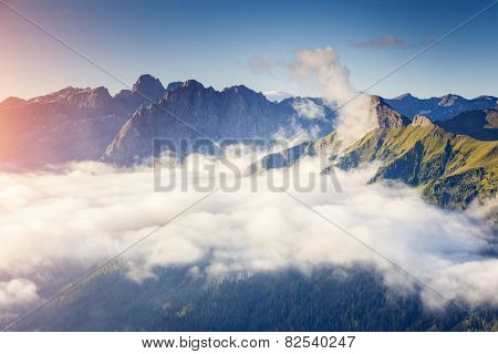 Great view of the foggy Val di Fassa valley with pass Sella. National Park. Dolomites (Dolomiti), South Tyrol. Location Canazei, Campitello, Mazzin. Italy, Europe. Dramatic scene. Beauty world.