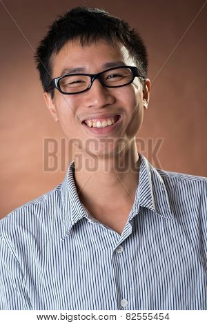 Young Chinese frank businessman, closeup portrait in studio.