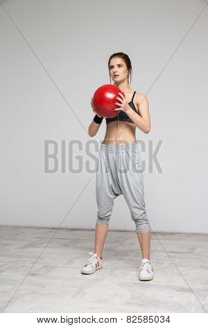 Beautiful sports woman working out with a medicine ball
