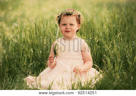Little girl smiling, child sitting on the grass