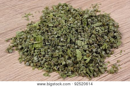 Heap Of Dried Green Marjoram On Wooden Background