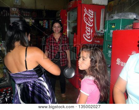 CEBU CITY, CEBU / PHILIPPINES - JULY 30, 2011: A woman makes a purchase at a small store in Cebu City in the Philippines.