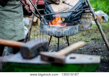 blacksmith forges detail. Blacksmith working outdoors. Master works on the anvil.