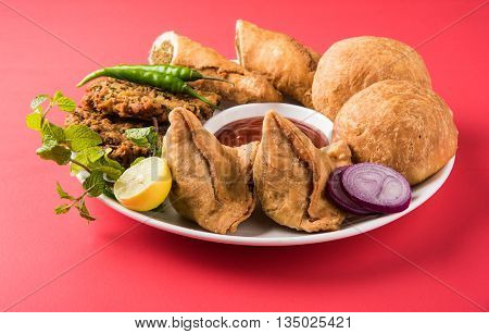coriander vada or kothimbir vada, samosa, kachori, daal vada on brown wooden planks. indian assorted snacks. Indian snacks combination. Indian snacks group, indian favourite snacks, asian spicy snacks