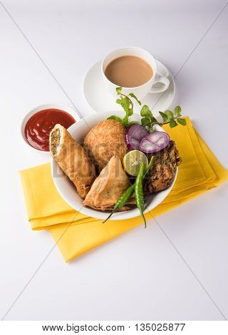 coriander vada or kothimbir vada, samosa, kachori, daal vada on brown wooden planks. indian assorted snacks. Indian snacks combination. Indian snacks group, indian favourite snacks, asian spicy snacks