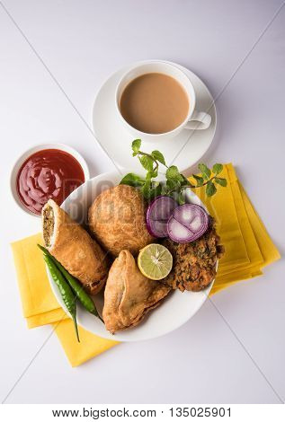 coriander vada or kothimbir vada, samosa, kachori, daal vada on brown wooden planks. indian assorted snacks. Indian snacks combination. Indian snacks group, indian favourite snacks, asian spicy snacks