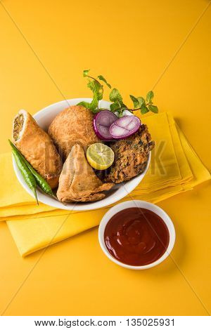 coriander vada or kothimbir vada, samosa, kachori, daal vada on brown wooden planks. indian assorted snacks. Indian snacks combination. Indian snacks group, indian favourite snacks, asian spicy snacks