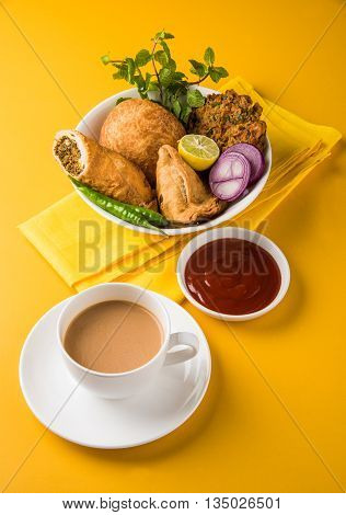 coriander vada or kothimbir vada, samosa, kachori, daal vada on brown wooden planks. indian assorted snacks. Indian snacks combination. Indian snacks group, indian favourite snacks, asian spicy snacks