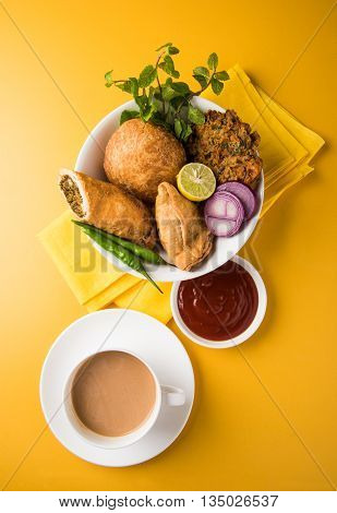 coriander vada or kothimbir vada, samosa, kachori, daal vada on brown wooden planks. indian assorted snacks. Indian snacks combination. Indian snacks group, indian favourite snacks, asian spicy snacks